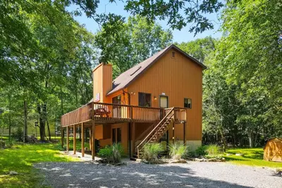 a large house with a deck and a staircase at The Burrow in Jim Thorpe