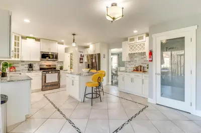 a kitchen with white cabinets and a yellow stool at Hot Tub! Family Tobyhanna Getaway 12 Mi to Slopes in Tobyhanna
