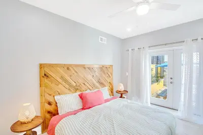 a bedroom with a bed with pink pillows and a window at Spacious Oasis - Parking, Private Patio & Roofdeck in Philadelphia