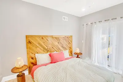 a bedroom with a large bed with a wooden headboard at Spacious Oasis - Parking, Private Patio & Roofdeck in Philadelphia