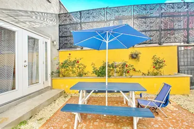 a blue picnic table with a blue umbrella and two chairs at Spacious Oasis - Parking, Private Patio & Roofdeck in Philadelphia