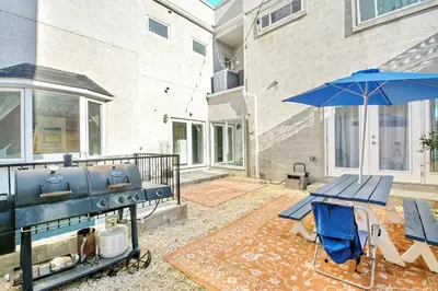 a patio with a grill and a picnic table and an umbrella at Spacious Oasis - Parking, Private Patio & Roofdeck in Philadelphia