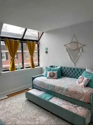 a bedroom with a bed and a couch and a window at A Regal Retreat- Exclusive Parking, Prime Location in Philadelphia