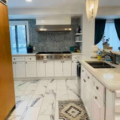 a large kitchen with white cabinets and a sink at A Regal Retreat- Exclusive Parking, Prime Location in Philadelphia