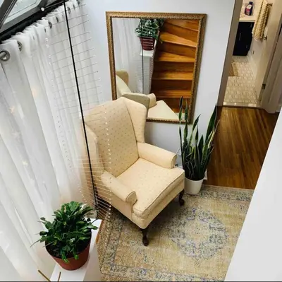 a living room with a chair and a mirror at A Regal Retreat- Exclusive Parking, Prime Location in Philadelphia