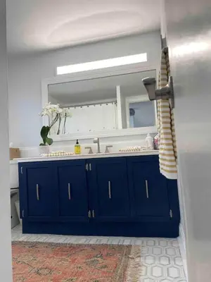 a bathroom with a blue vanity and a mirror at A Regal Retreat- Exclusive Parking, Prime Location in Philadelphia