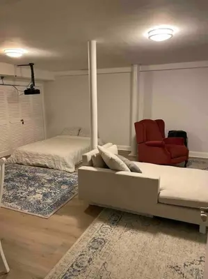a bedroom with a bed and a red chair at A Regal Retreat- Exclusive Parking, Prime Location in Philadelphia