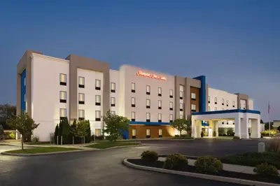 a large white building with a parking lot at Hampton Inn & Suites York South in York