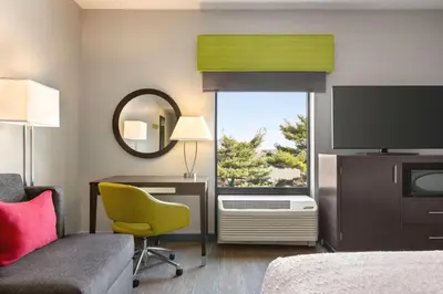 a hotel room with a bed and a desk and a television at Hampton Inn & Suites York South in York