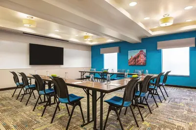 a conference room with a table and chairs and a screen at Hampton Inn & Suites York South in York