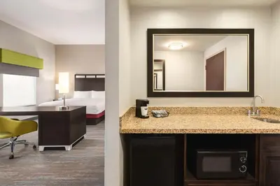 a hotel room with a sink and a mirror at Hampton Inn & Suites York South in York