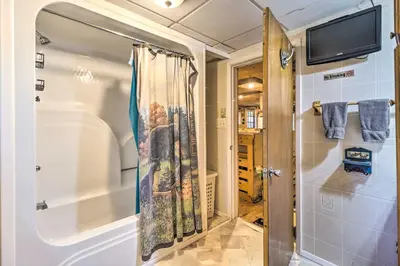 a bathroom with a shower and a tub at Secluded and Quiet Pocono Mountain Cabin with Hot Tub! in Kunkletown