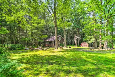 a large yard with a log cabin in the woods at Secluded and Quiet Pocono Mountain Cabin with Hot Tub! in Kunkletown