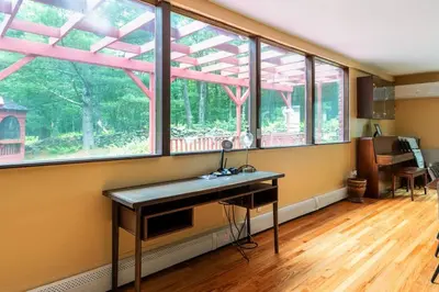 a room with a desk in front of some windows at Sunset Estate in the Catskills in Monticello