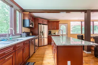 a large kitchen with wooden cabinets and granite counter tops at Sunset Estate in the Catskills in Monticello