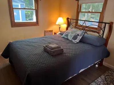 a suitcase sitting on a bed in a bedroom at Romantic Pocono house - stream, lake, beach, pool, firepit in Locust Lakes Village