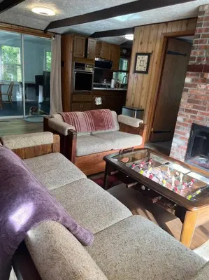 a living room with two couches and a table at Romantic Pocono house - stream, lake, beach, pool, firepit in Locust Lakes Village