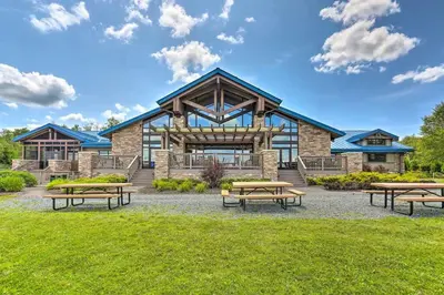 a building with picnic tables in front of it at Romantic Pocono house - stream, lake, beach, pool, firepit in Locust Lakes Village