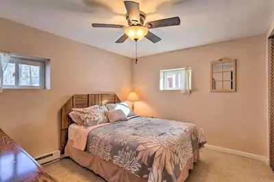 a bedroom with a bed with a ceiling fan at Peaceful Pocono Lakefront, beach, pools, firepit, pets in Arrowhead Lake