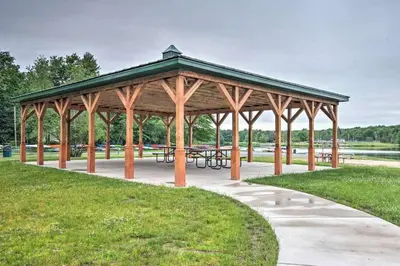 a wooden pavilion with picnic tables in a park at Peaceful Pocono Lakefront, beach, pools, firepit, pets in Arrowhead Lake