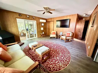 a living room with a couch and a red rug at Peaceful Pocono Lakefront, beach, pools, firepit, pets in Arrowhead Lake