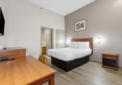 a bedroom with a bed and a desk and a table at Edison Motor Lodge in Edison