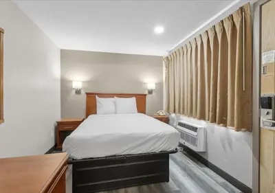 a hotel room with a bed and a desk at Edison Motor Lodge in Edison