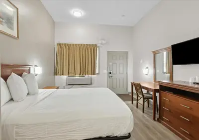 a hotel room with a large bed and a desk at Edison Motor Lodge in Edison