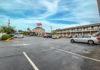 a parking lot with cars parked in front of a hotel at Edison Motor Lodge in Edison