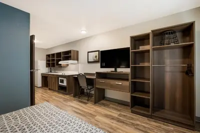 an apartment bedroom with a desk and a television at WoodSpring Suites South Brunswick - Princeton in Monmouth Junction