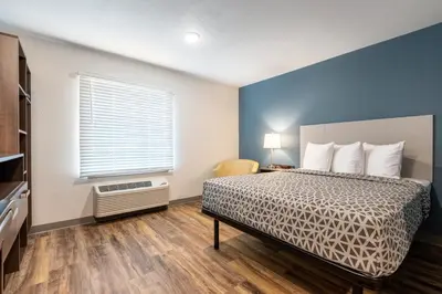 a bedroom with a bed and a window at WoodSpring Suites South Brunswick - Princeton in Monmouth Junction