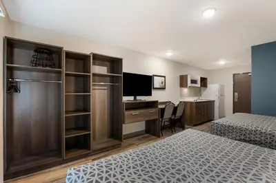 a bedroom with two beds and a desk with a computer at WoodSpring Suites South Brunswick - Princeton in Monmouth Junction
