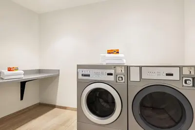 a laundry room with a washing machine and a counter at SpringHill Suites by Marriott Camp Hill in Camp Hill