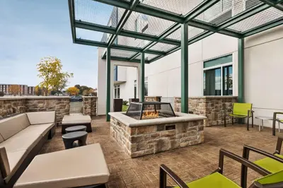 an outdoor patio with a fireplace and furniture at SpringHill Suites by Marriott Camp Hill in Camp Hill