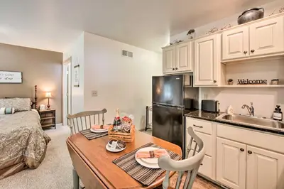 a kitchen and living room with a table and a refrigerator at Cozy Garden Room in Welsh Mountain Suites! in New Holland