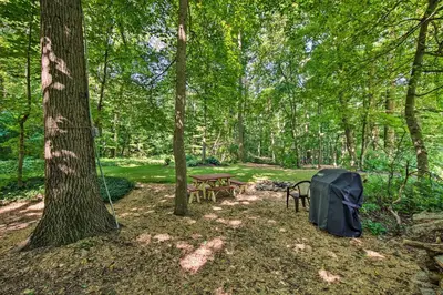 a picnic table and a tent in the woods at Cozy Garden Room in Welsh Mountain Suites! in New Holland