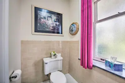 a bathroom with a toilet and a window with pink curtains at 8 Mi to Hersheypark Millard Mansion in Annville in Annville