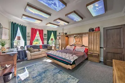 a bedroom with a bed and a living room withwindows at 8 Mi to Hersheypark Millard Mansion in Annville in Annville