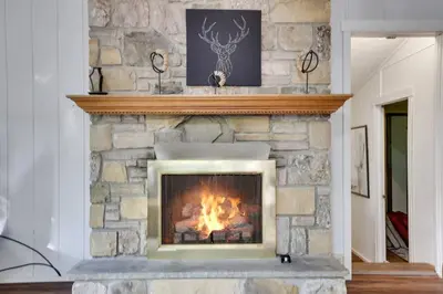 a fireplace in a living room with a stone wall at Pet Friendly Ski Retreat in Lake Community in Locust Lakes Village