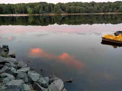 a yellow boat on a lake with trees in the background at Pet Friendly Ski Retreat in Lake Community in Locust Lakes Village