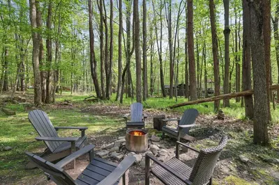 a group of chairs and a fire pit in the woods at Pet Friendly Ski Retreat in Lake Community in Locust Lakes Village