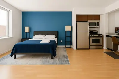 a blue bedroom with a bed and a kitchen at Studio apart Time Square in New York