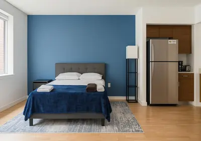 a blue bedroom with a bed and a refrigerator at Studio apart Time Square in New York