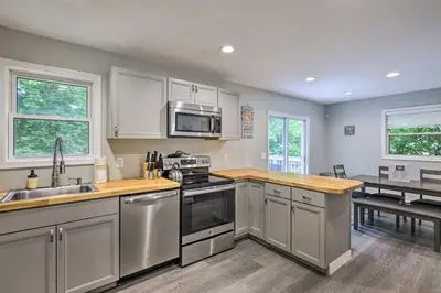 a kitchen with stainless steel appliances and a table at Furnished Deck and Lake Access Poconos Place! in Tobyhanna