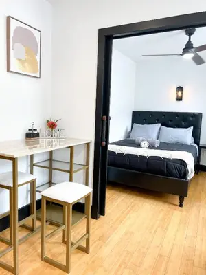 a bedroom with a bed and a desk and a table at Boutique Studio Apartment on Grand Ave in Englewood