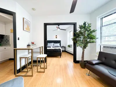 a living room with a bed and a mirror at Boutique Studio Apartment on Grand Ave in Englewood