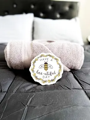 a pair of towels with a bee invitation on them at Boutique Studio Apartment on Grand Ave in Englewood
