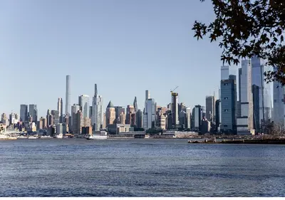a view of a large city from the water at Dharma Home Suites Hoboken in Hoboken