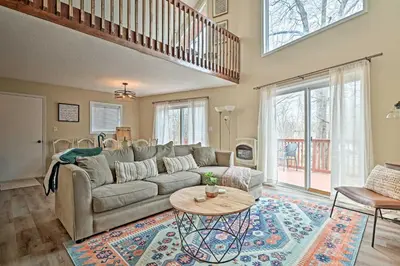 a living room with a couch and a table at Golf, Ski and Fish Cabin with Deck in Tobyhanna! in Tobyhanna