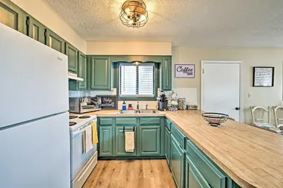 a kitchen with green cabinets and a white refrigerator at Golf, Ski and Fish Cabin with Deck in Tobyhanna! in Tobyhanna